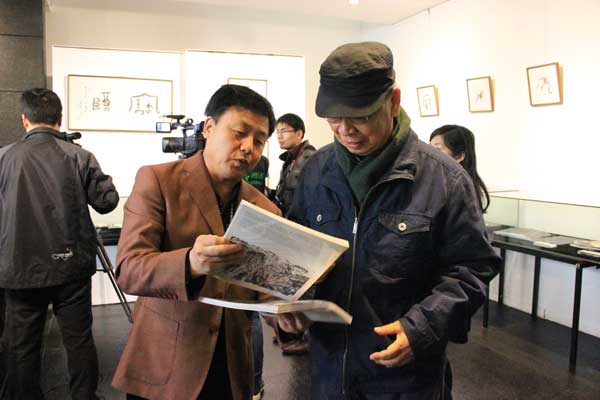 总编杨焦点向著名画家、书法金石家张道兴介绍《艺术天成》杂志